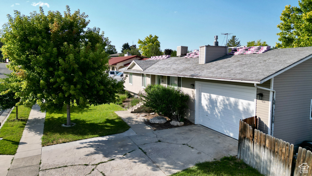 View of property exterior featuring a garage and a lawn