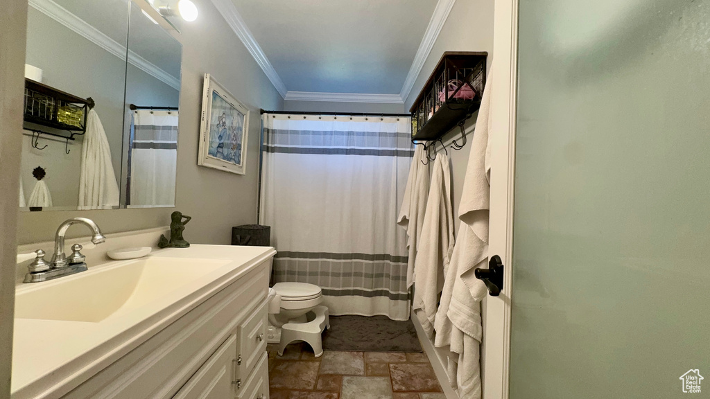 Bathroom with vanity, toilet, tile patterned floors, and crown molding