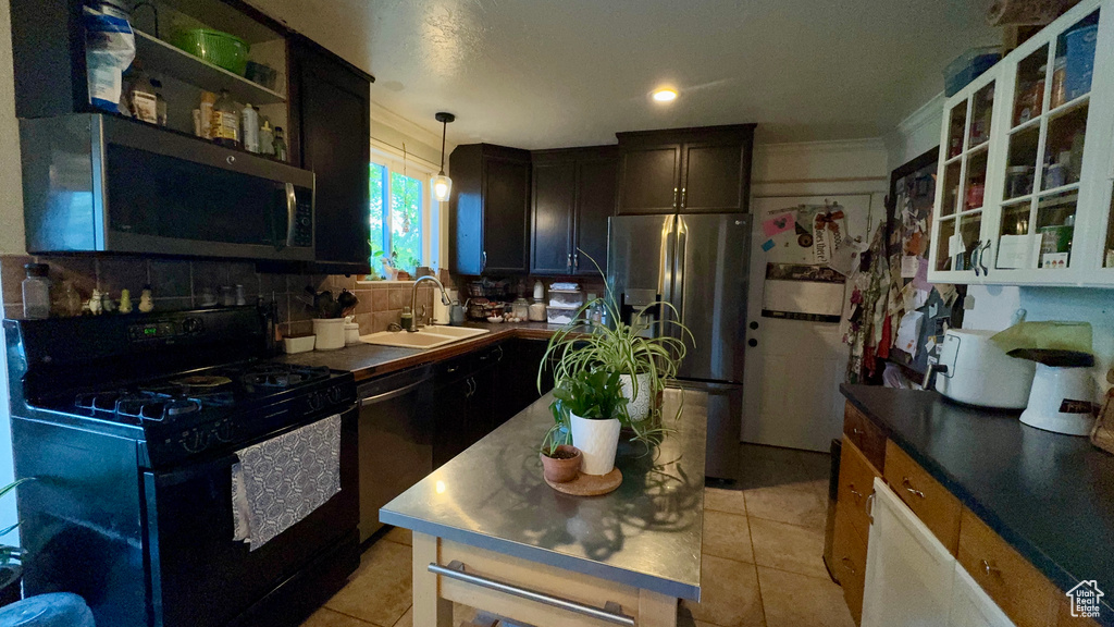 Kitchen featuring black appliances, hanging light fixtures, decorative backsplash, sink, and light tile patterned floors