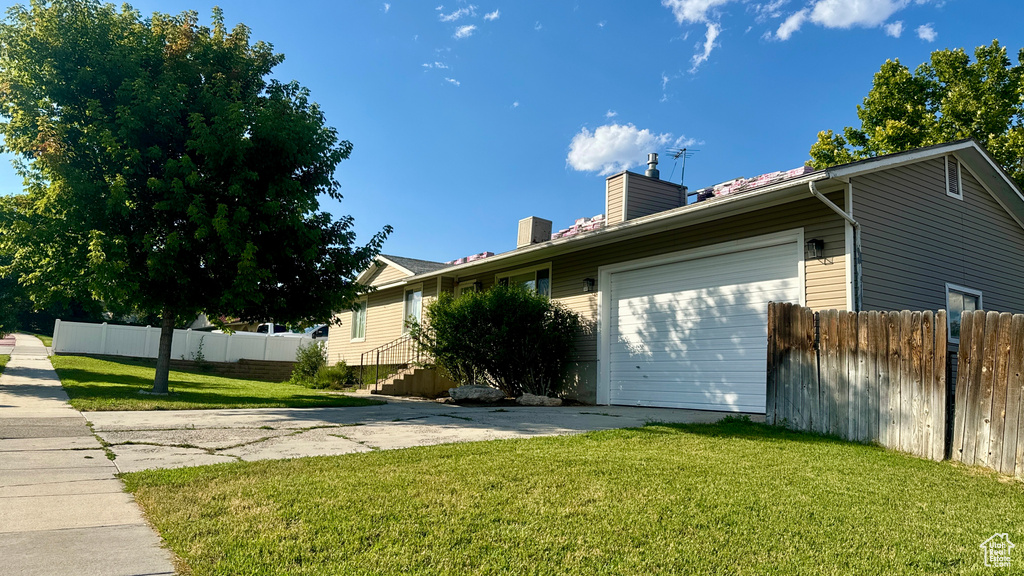 View of front of house featuring a garage and a front yard