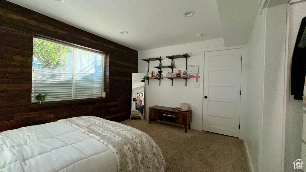 Bedroom with wood walls and carpet