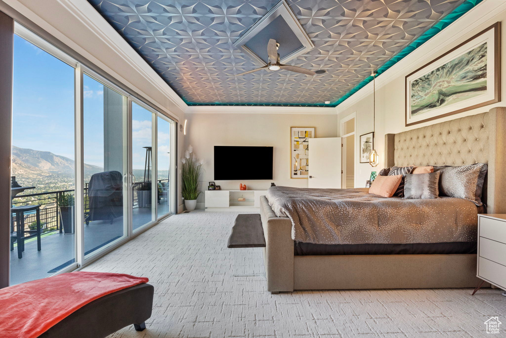 Bedroom featuring a mountain view, access to exterior, crown molding, and multiple windows