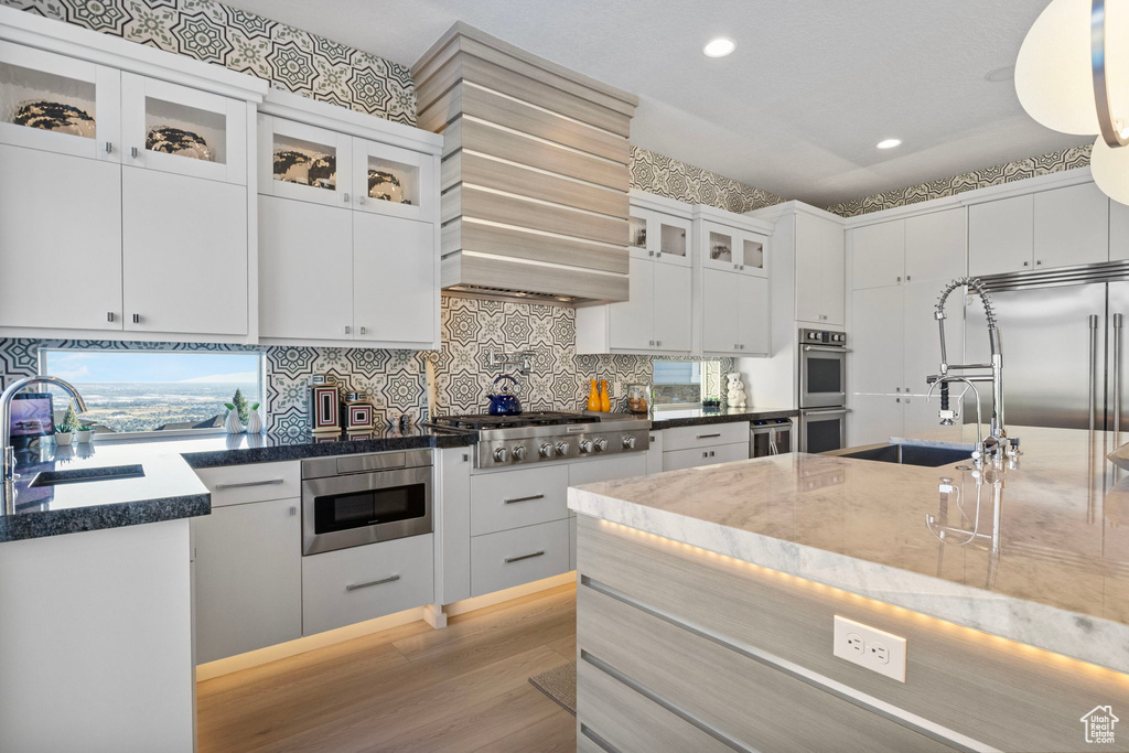 Kitchen featuring white cabinetry, tasteful backsplash, sink, dark stone countertops, and appliances with stainless steel finishes