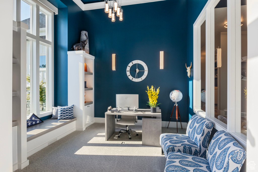 Home office featuring carpet flooring, ornamental molding, and a notable chandelier