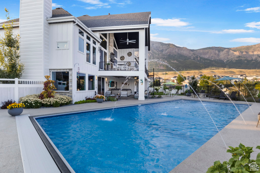 View of swimming pool featuring a mountain view, pool water feature, and a patio