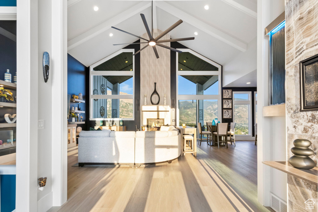 Interior space featuring beamed ceiling, high vaulted ceiling, ceiling fan, and hardwood / wood-style floors