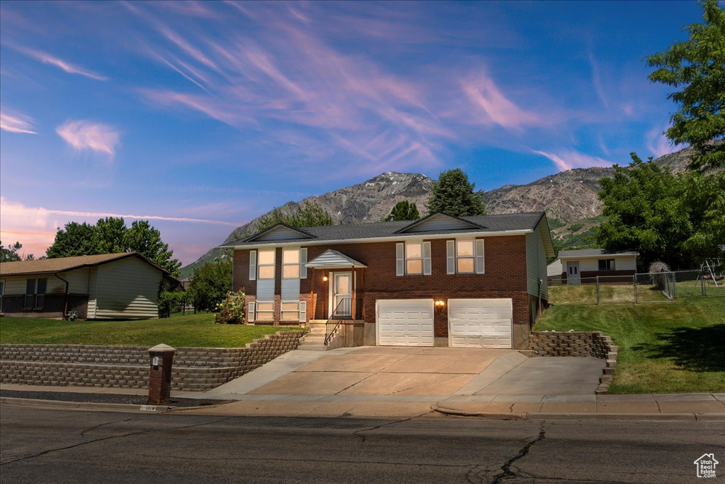 Bi-level home with a mountain view, a garage, and a yard