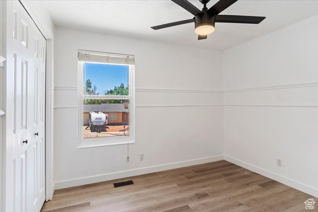 Unfurnished room featuring ceiling fan and light wood-type flooring