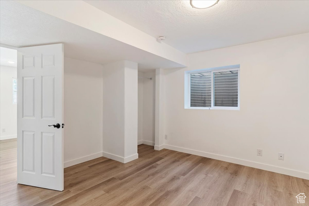 Unfurnished bedroom with light hardwood / wood-style flooring and a textured ceiling