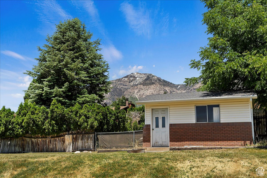 View of front of home featuring a mountain view and a front lawn