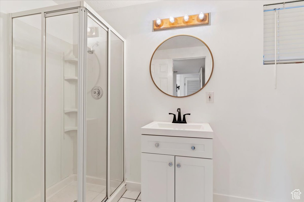 Bathroom with vanity, walk in shower, and tile patterned floors