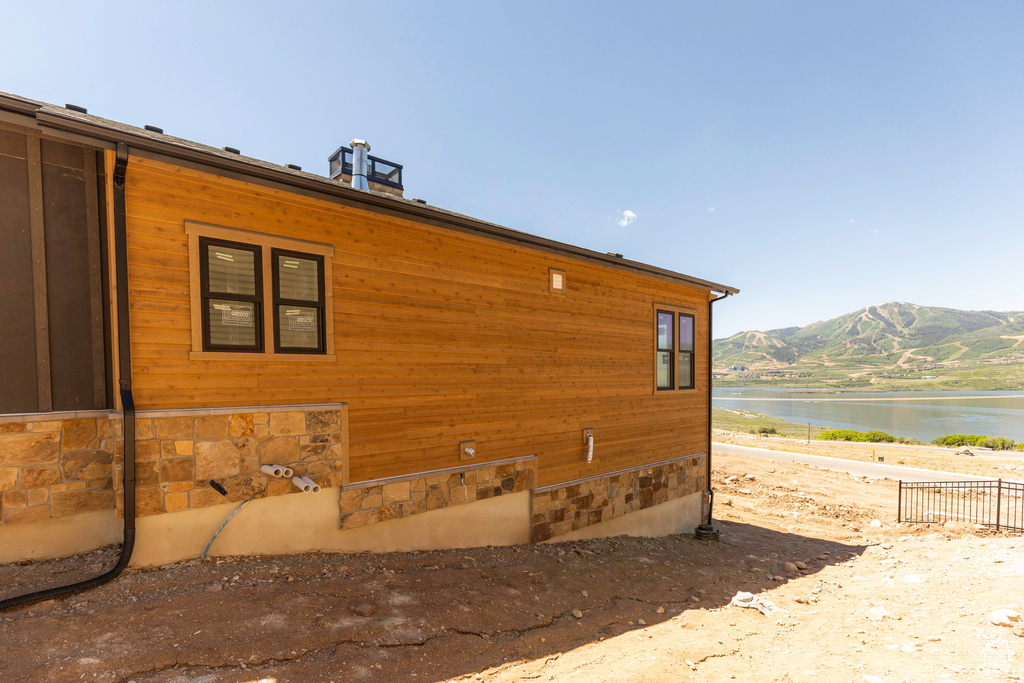 View of property exterior featuring a water and mountain view