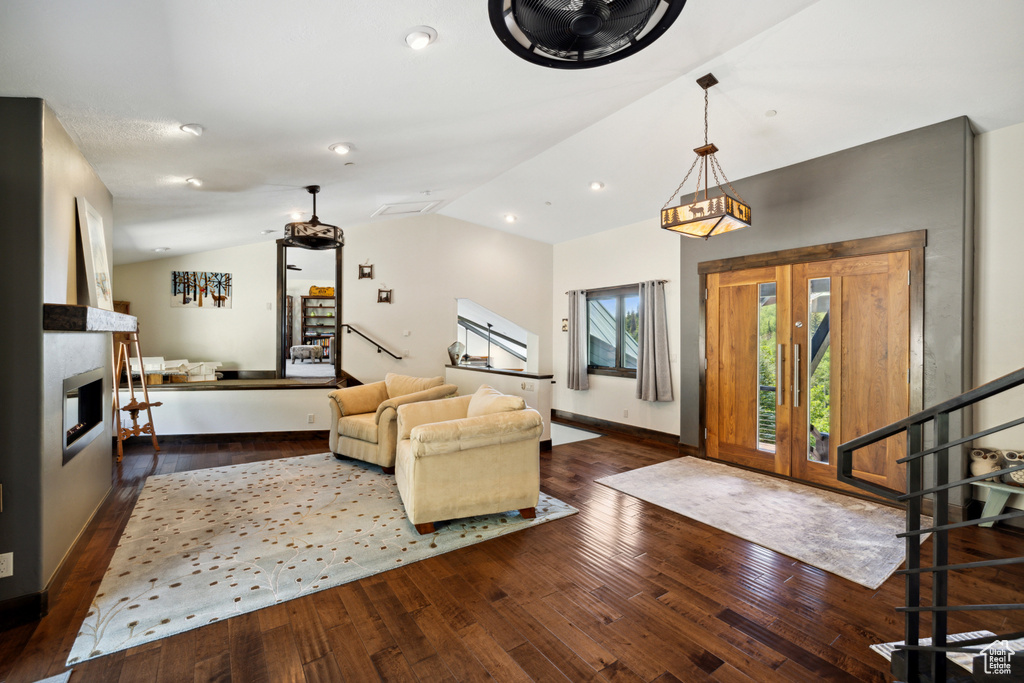 Entryway with wood-type flooring, lofted ceiling, and a large fireplace