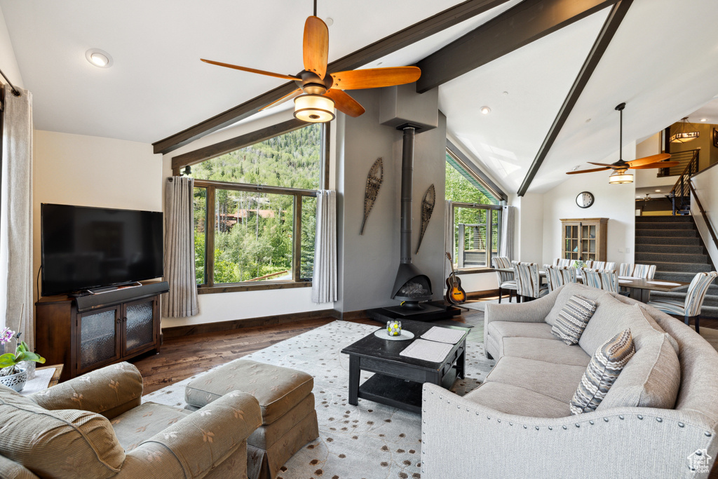 Living room with ceiling fan, beamed ceiling, wood-type flooring, and high vaulted ceiling