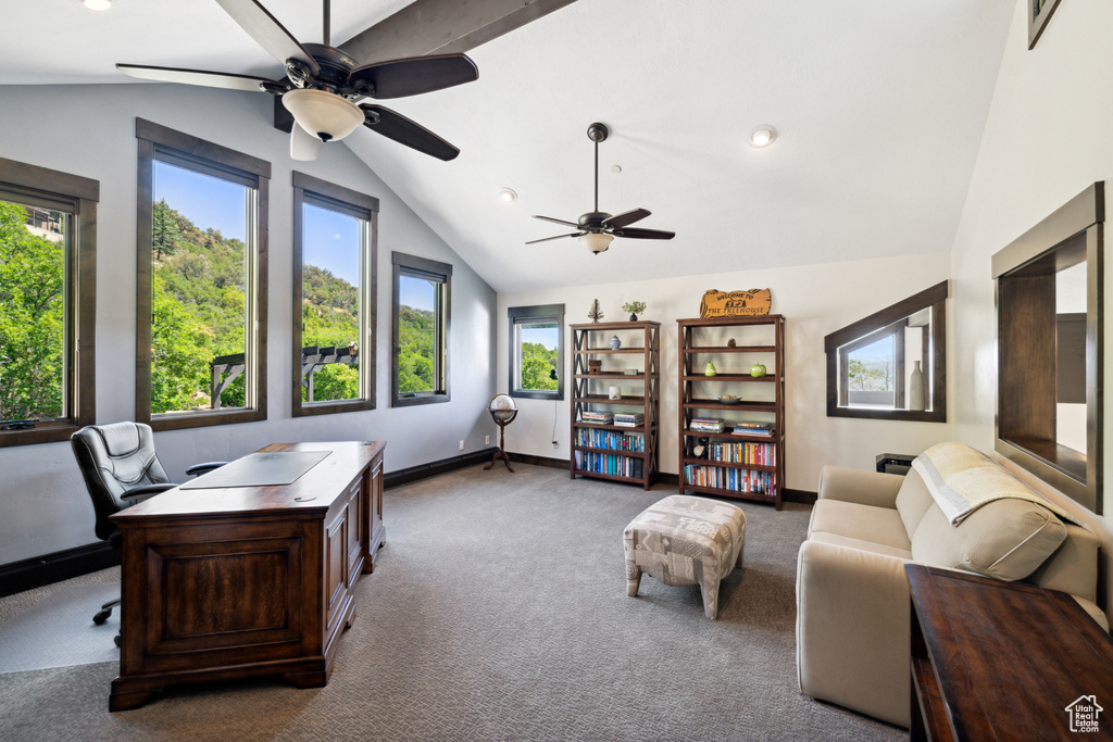 Carpeted home office featuring ceiling fan, vaulted ceiling, and a wealth of natural light