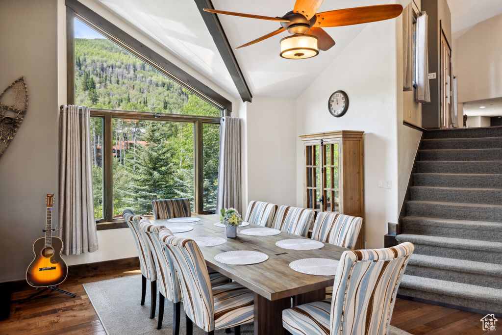 Dining area with vaulted ceiling, ceiling fan, and dark wood-type flooring