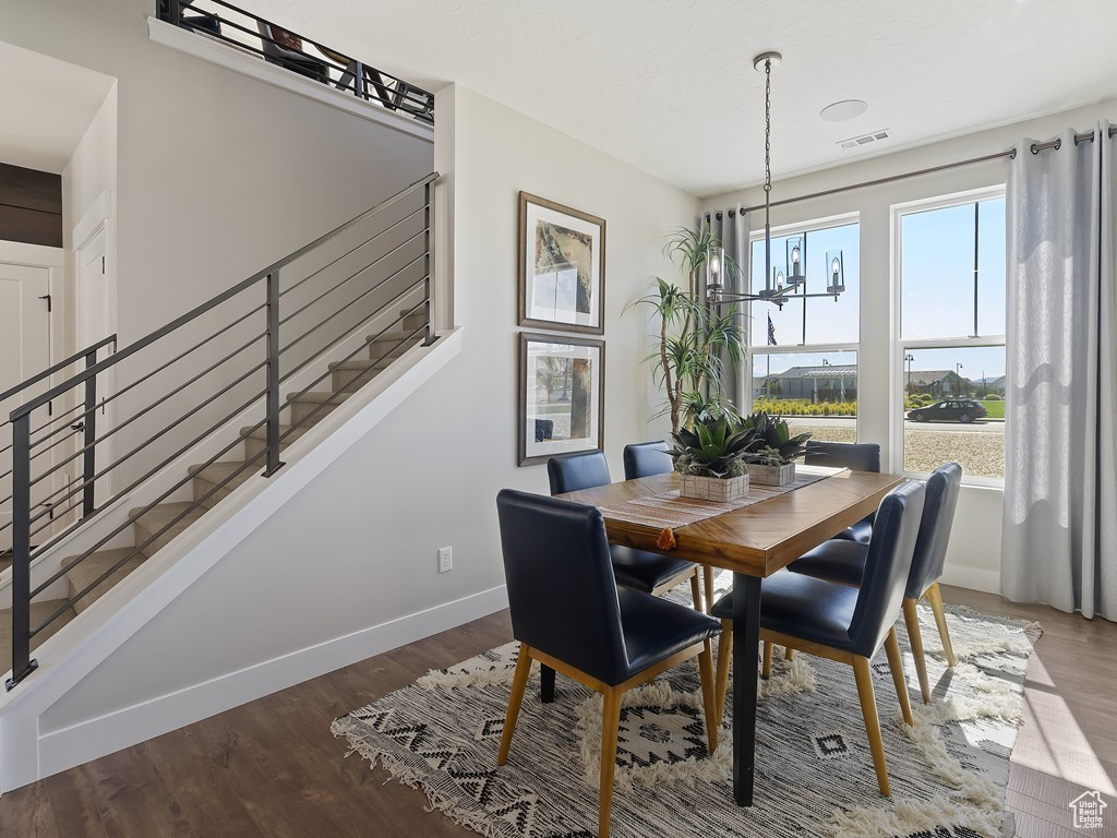 Dining room with hardwood / wood-style flooring and a notable chandelier