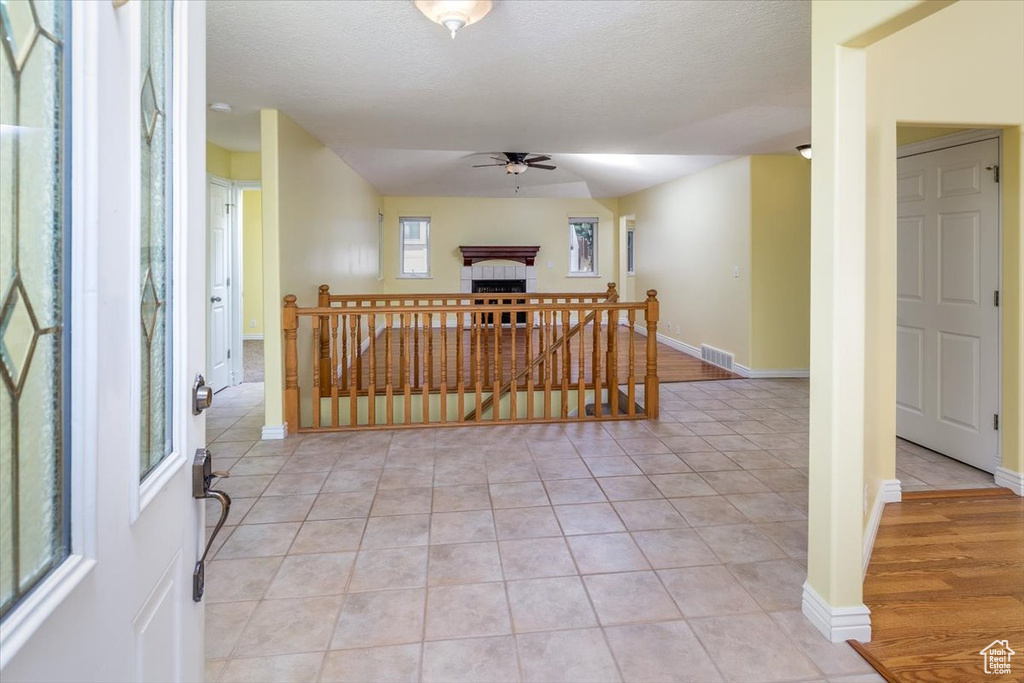 Interior space featuring a textured ceiling, light wood-type flooring, and ceiling fan