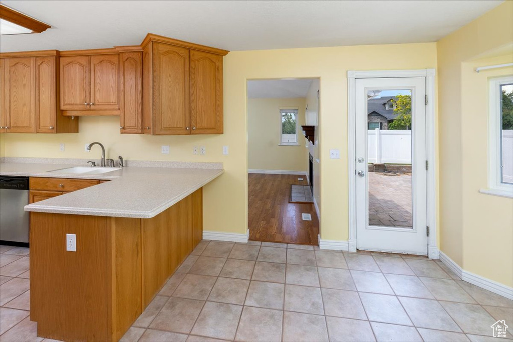 Kitchen featuring sink, kitchen peninsula, dishwasher, and light hardwood / wood-style floors