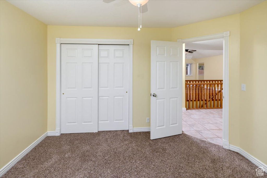 Unfurnished bedroom with carpet, a closet, and ceiling fan