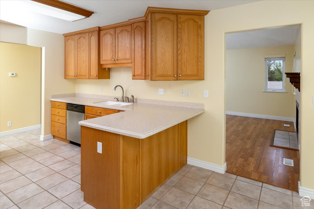 Kitchen featuring light hardwood / wood-style floors, sink, dishwasher, and kitchen peninsula