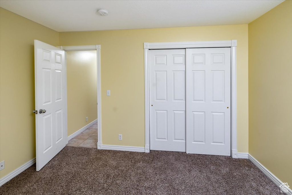 Unfurnished bedroom featuring a closet and carpet floors