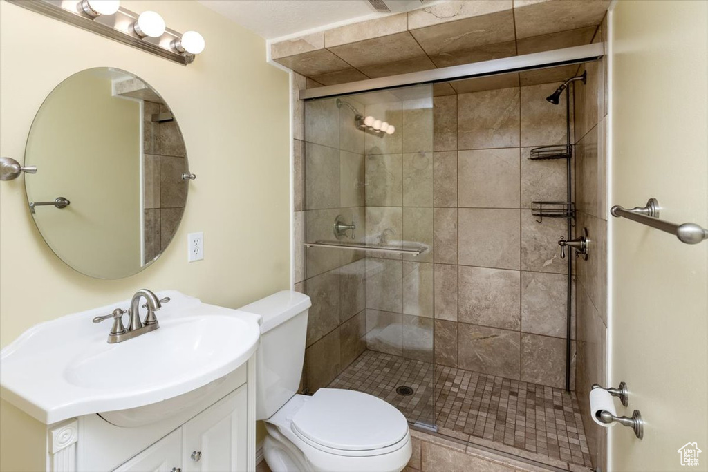 Bathroom with toilet, vanity, and an enclosed shower