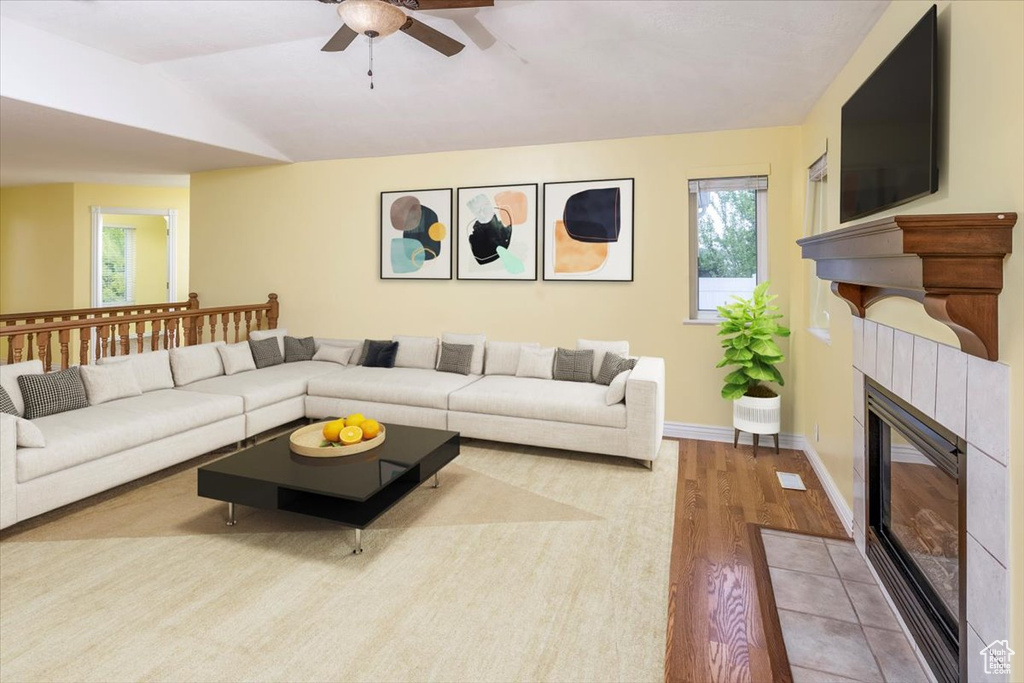 Living room with a fireplace, ceiling fan, and hardwood / wood-style floors