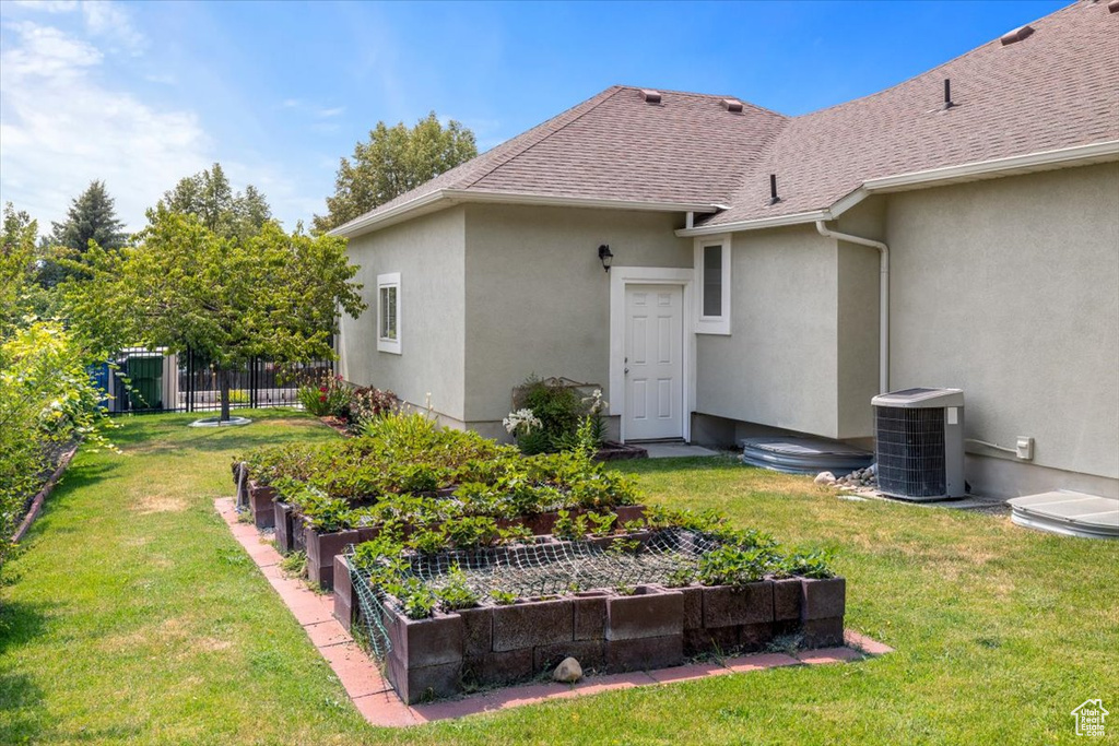 Back of house with a lawn and cooling unit