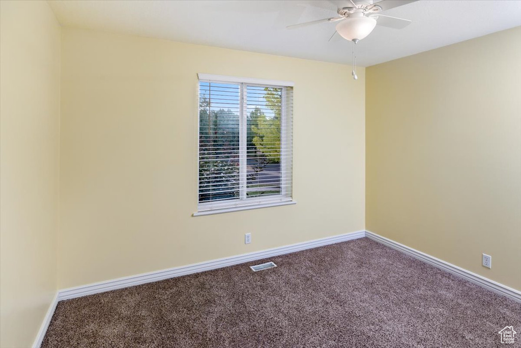 Unfurnished room featuring ceiling fan and carpet flooring