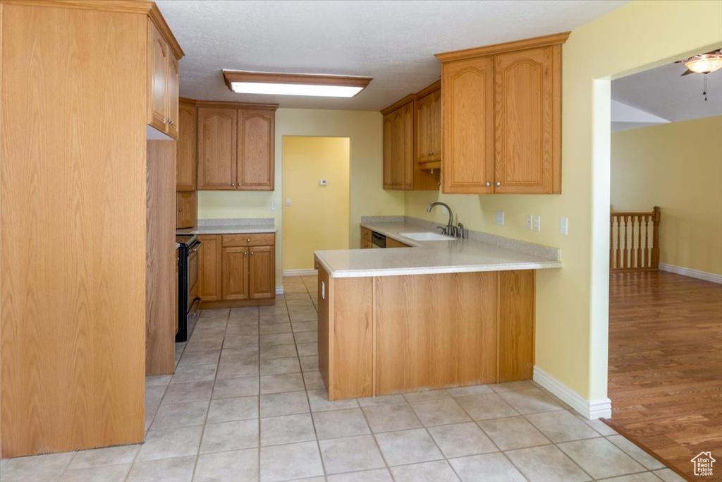 Kitchen featuring sink, light hardwood / wood-style flooring, stainless steel electric stove, and kitchen peninsula