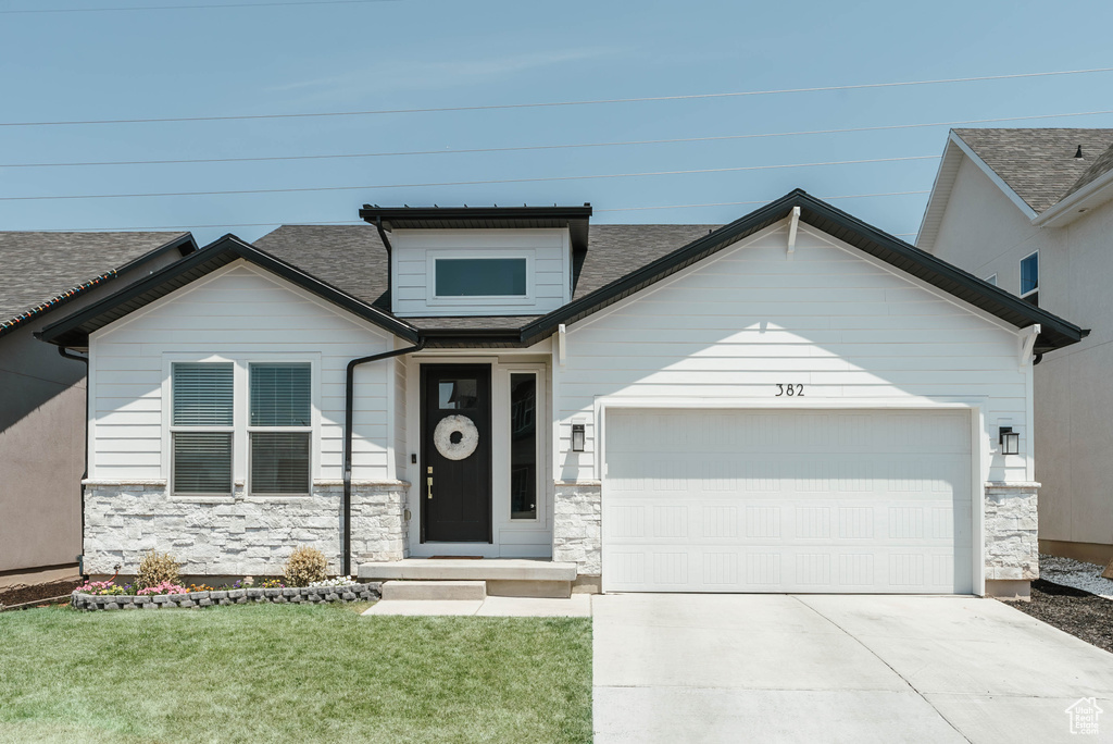 View of front of house featuring a garage and a front lawn