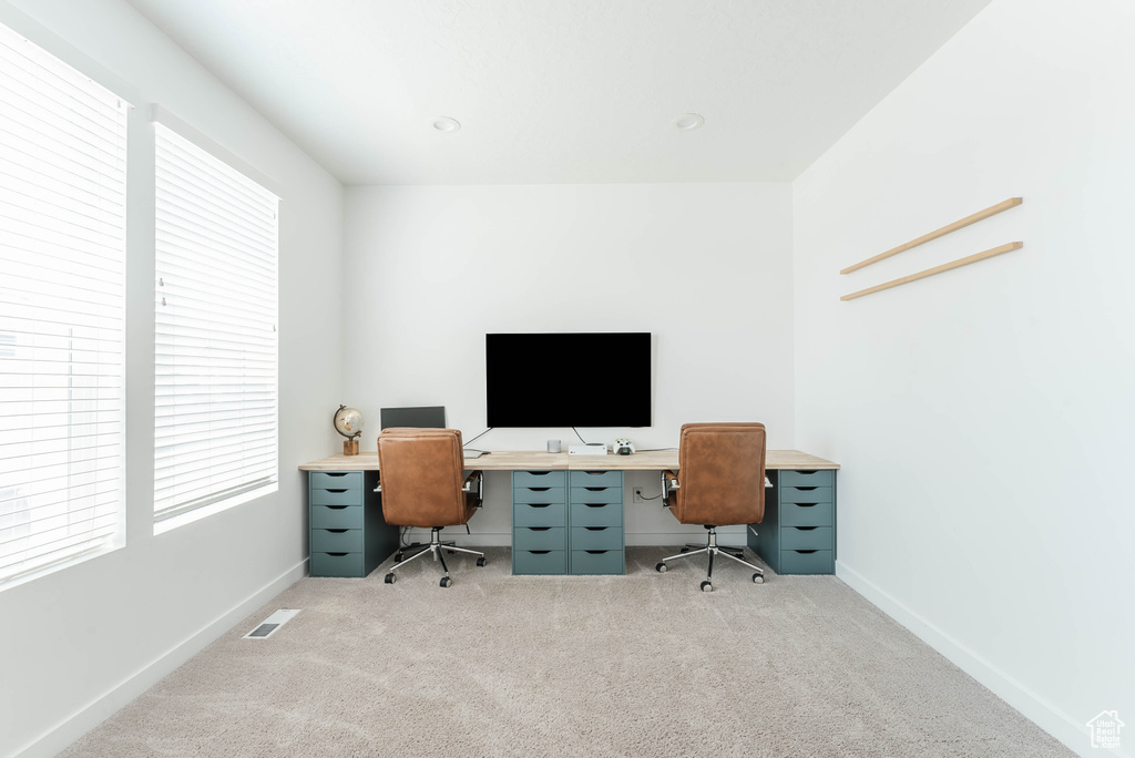 Carpeted home office with plenty of natural light