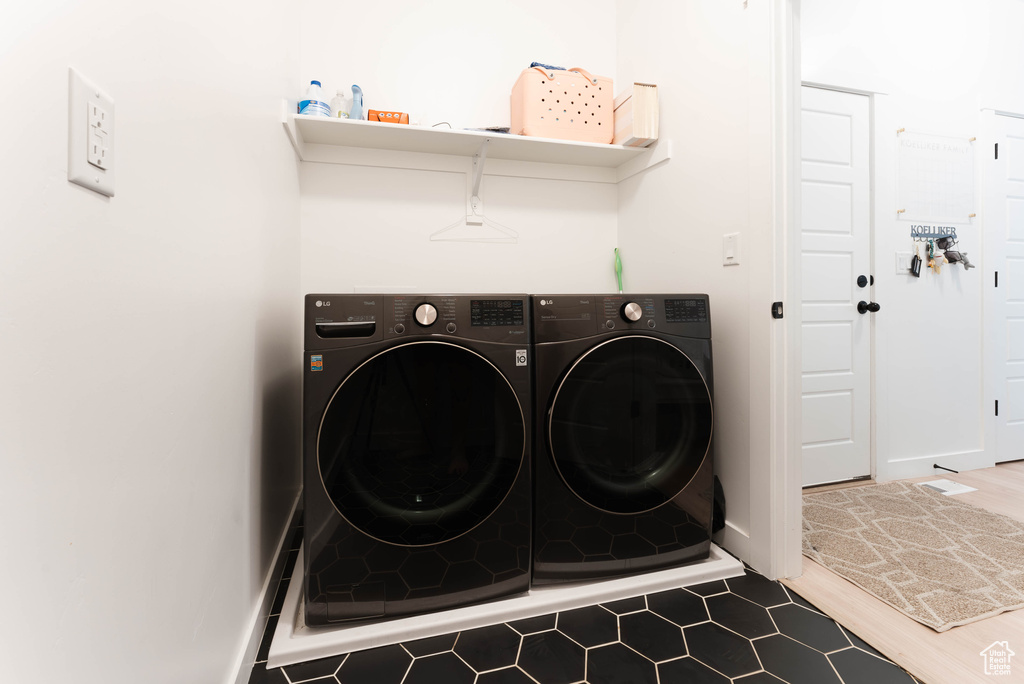 Clothes washing area featuring dark hardwood / wood-style flooring and washing machine and dryer
