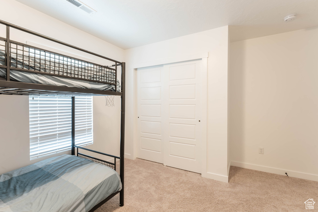 Carpeted bedroom with a closet