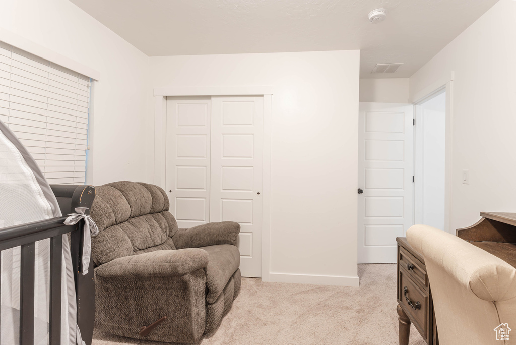 Bedroom with light carpet and a closet