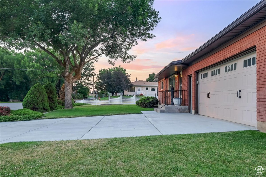 Yard at dusk featuring a garage