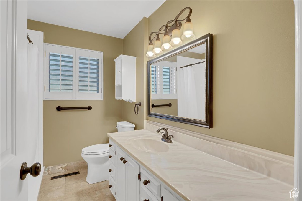 Bathroom featuring tile patterned floors, vanity, and toilet