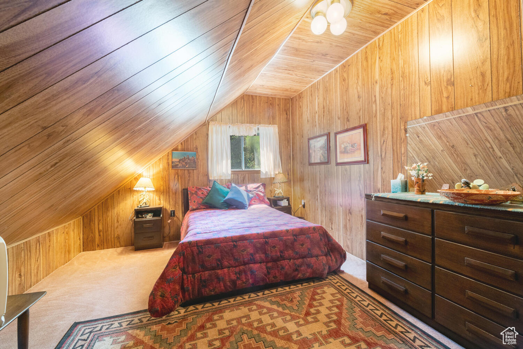 Bedroom with carpet, wooden walls, and wooden ceiling