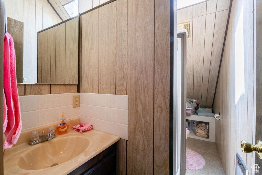 Bathroom featuring vanity and tile walls