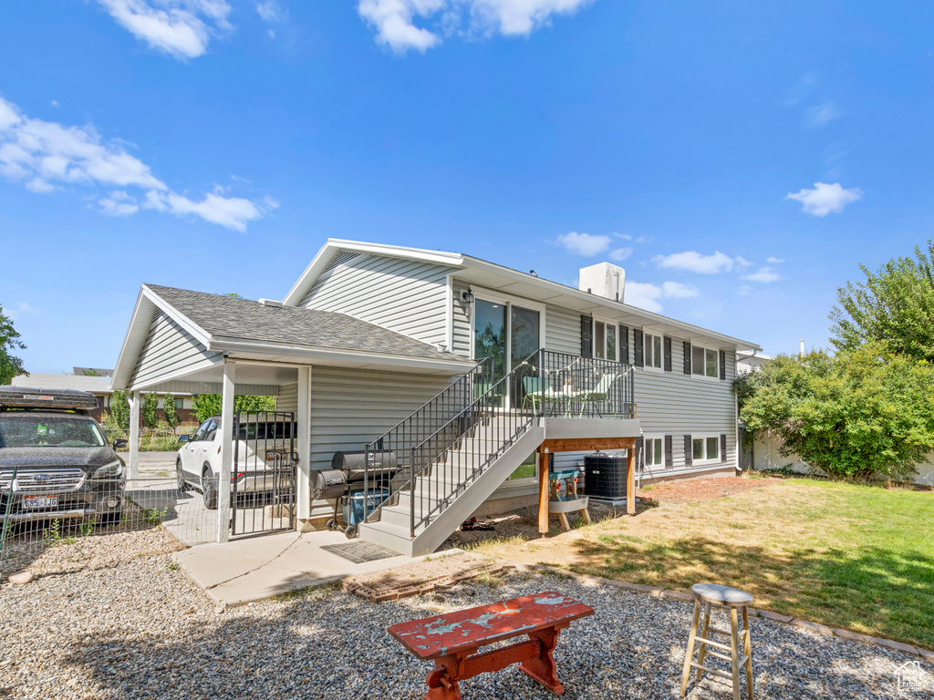 Rear view of house with a carport and a yard