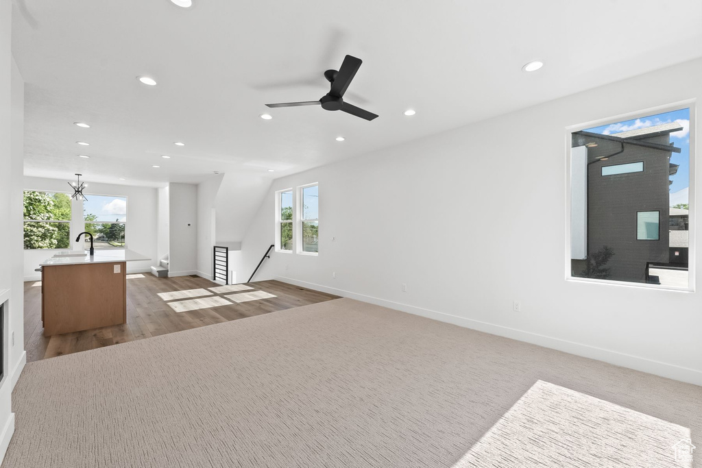 Living room with a healthy amount of sunlight, sink, light wood-type flooring, and ceiling fan