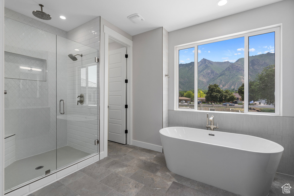 Bathroom featuring a mountain view, plus walk in shower, tile patterned floors, and tile walls