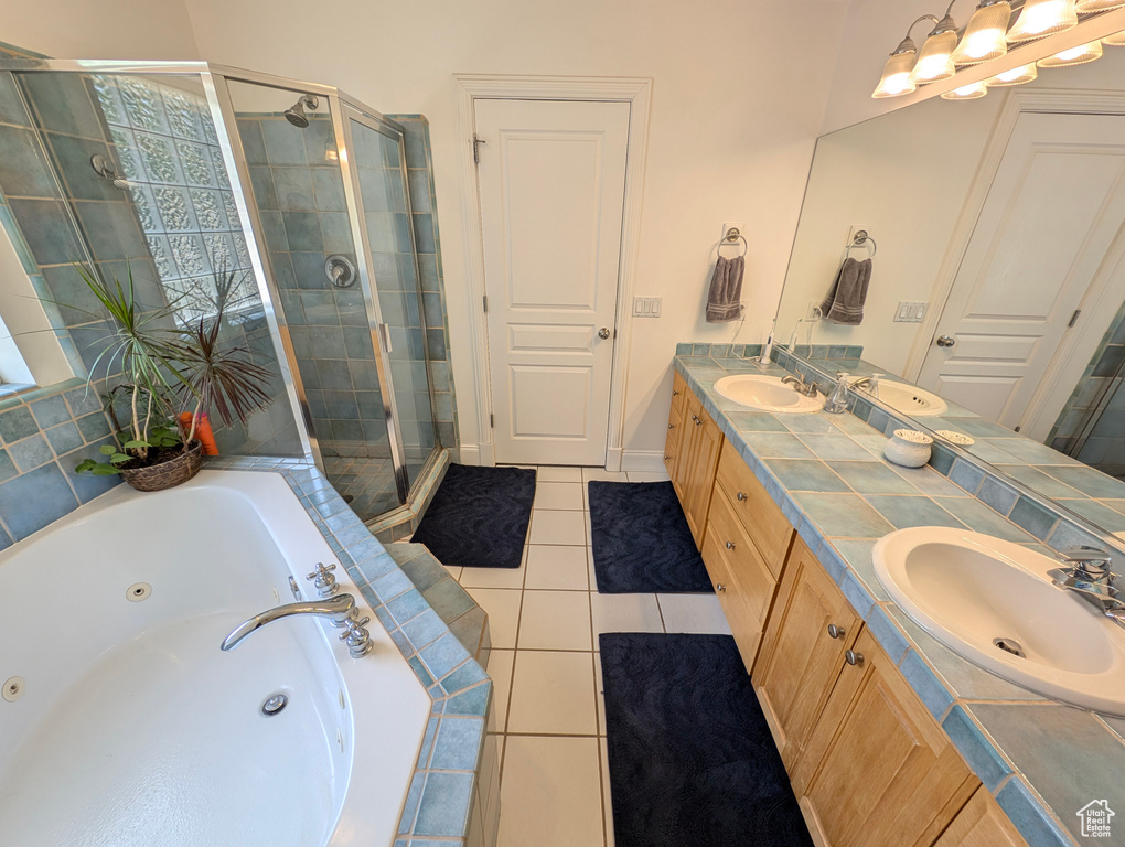 Bathroom with independent shower and bath, tile patterned floors, and double sink vanity