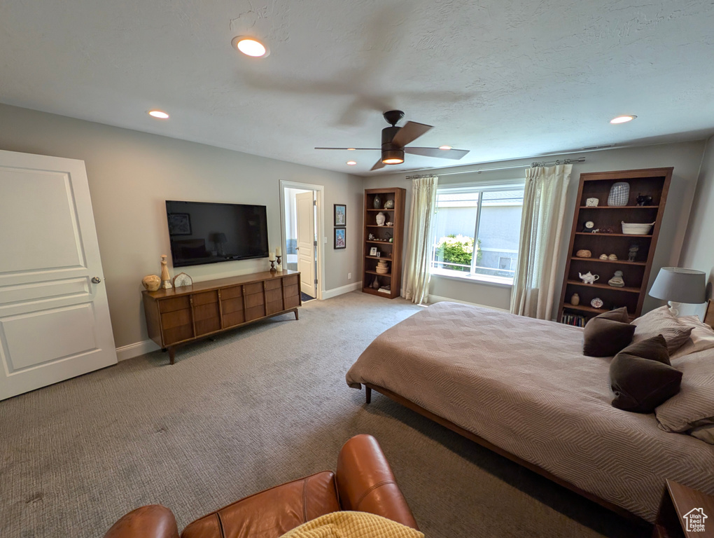 Carpeted bedroom featuring ceiling fan