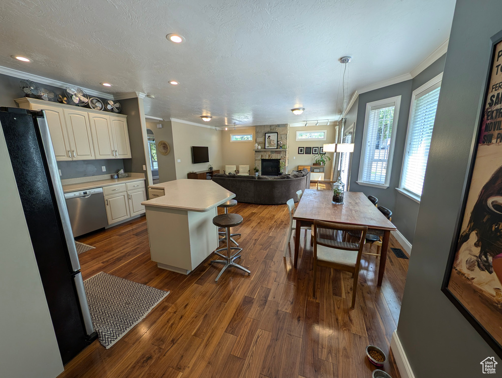 Kitchen featuring a fireplace, crown molding, and hardwood / wood-style floors