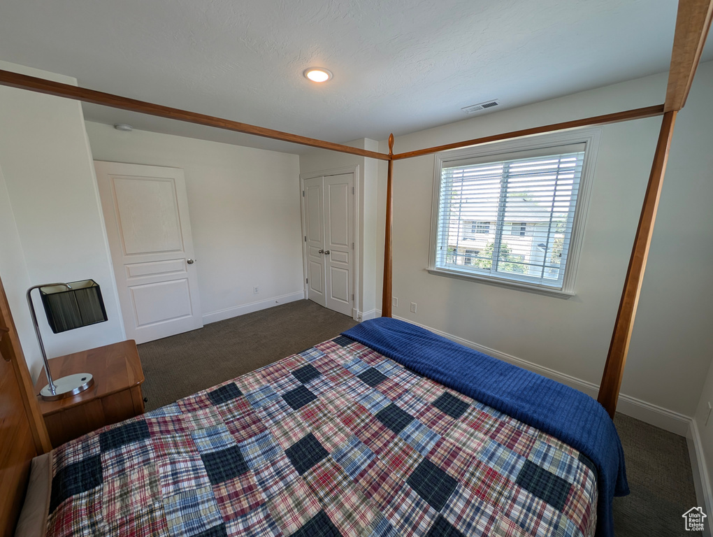 Bedroom featuring dark carpet and a closet