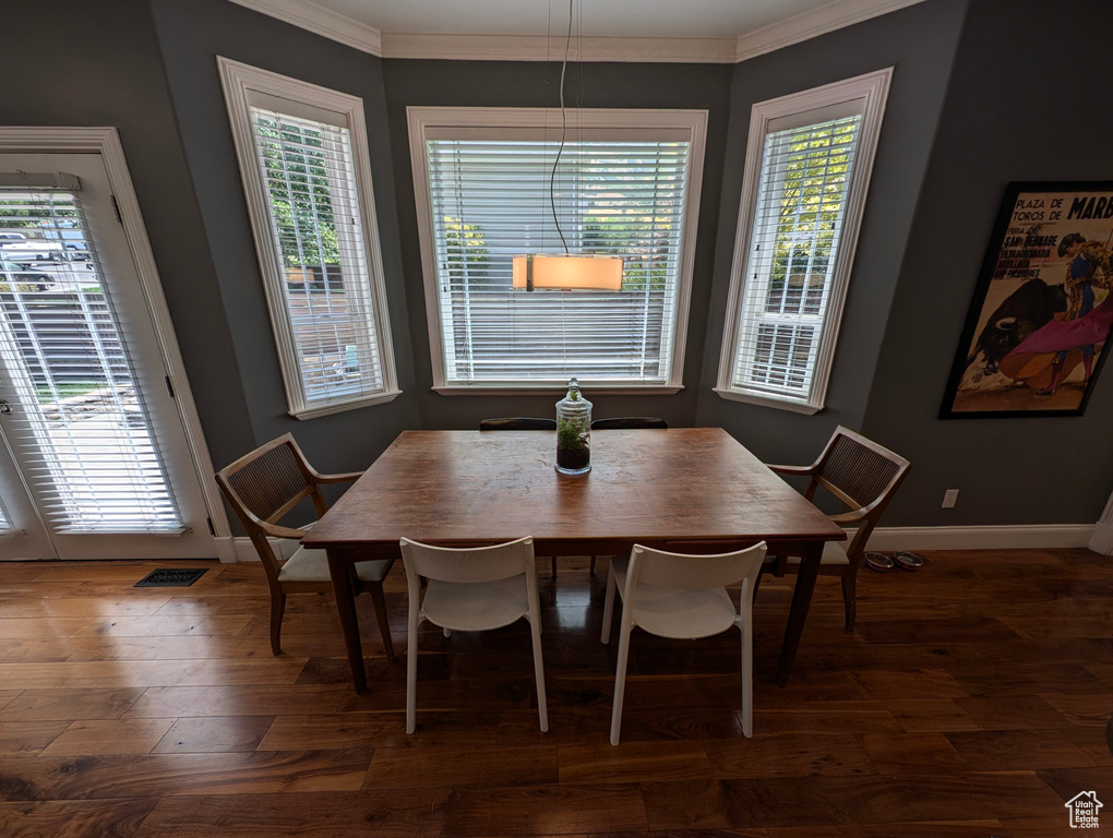 Dining space featuring dark wood-type flooring and ornamental molding