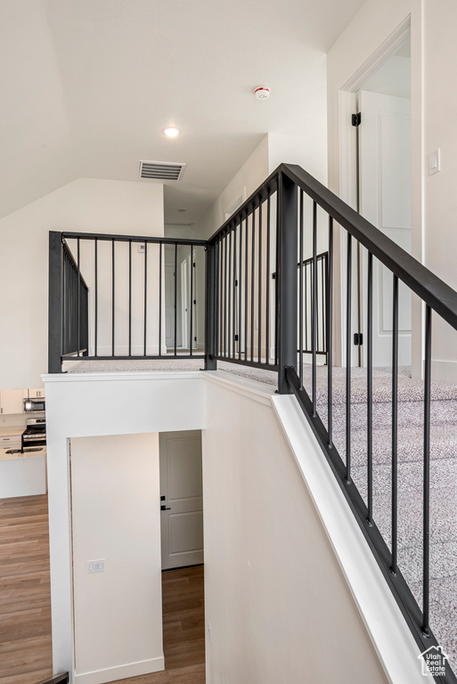 Staircase featuring hardwood / wood-style flooring