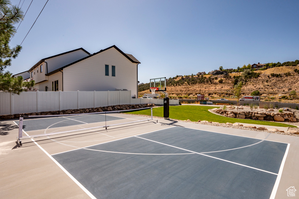 View of tennis court with basketball hoop